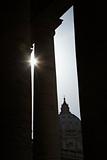 Sun peeking through doric columns in Saint Peter's Square in Vat
