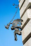 Winged gargoyle chained to wall.