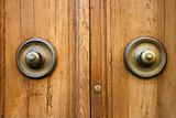 Brass doorknobs on wooden door.