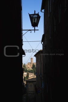 Street lamp viewed through darkened alley.