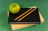 School books with green apple