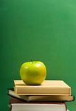 School books on green with apple