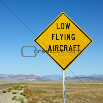 Low flying aircraft sign on side of highway.