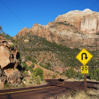 Curve caution sign on road winding through desert of Zion Nation