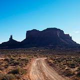 Dirt road and rock formations in Monument Valley, Utah.