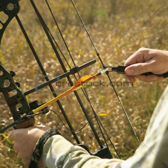 Bow hunter hands on compound bow.