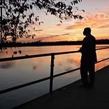 African-American man standing by water at sunset in Washington, 