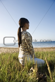 Woman sitting and  looking out to ocean.