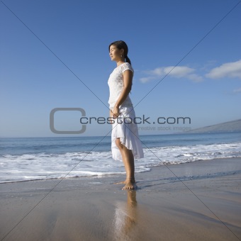 Woman standing at shoreline.