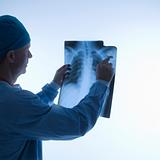 Mid-adult Caucasian male doctor pointing at an x-ray.