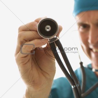 Doctor holding a stethoscope out towards viewer.