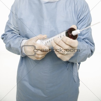 Male holding an oversized syringe.