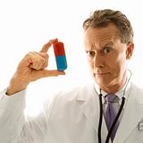 Doctor holding an oversized pill.