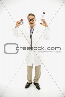 Doctor holding an oversized pill and syringe.