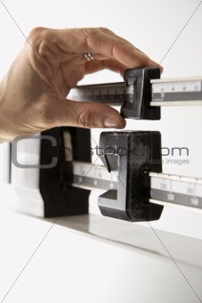 Female's hand reading weight on scale.