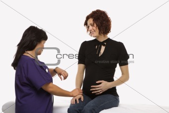 Pregnant woman having vital signs checked.
