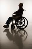 Silhouette of elderly man in wheelchair.