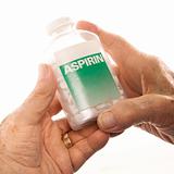 Hands holding aspirin bottle.