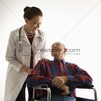 Doctor looking at an elderly man in wheelchair.