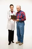 Doctor showing papers to elderly man.