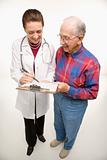 Doctor showing papers to elderly man.