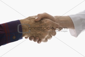 Close-up of elderly man shaking hands with female hand.