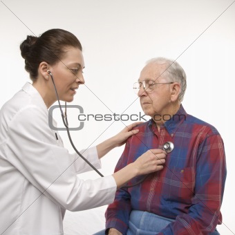 Doctor listening  to elderly man's heart with stethoscope.