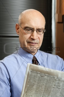 Caucasian businessman reading newspaper.