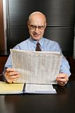 Caucasian businessman reading newspaper.