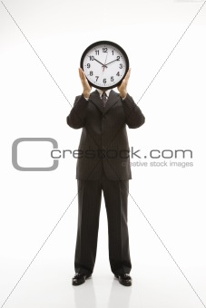 Businessman holding clock.