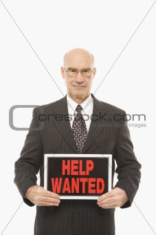 Businessman holding help wanted sign.