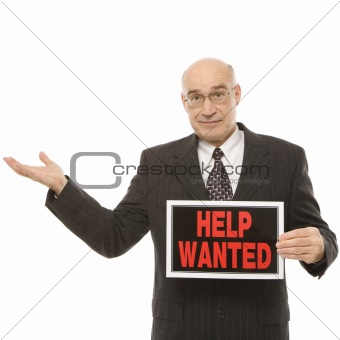 Businessman holding help wanted sign.