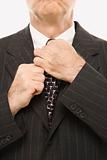 Businessman straightening necktie.