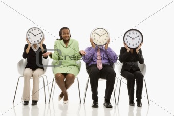 Business people covering faces with clocks and businesswoman shr
