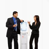 Businessman and businesswoman conversing at water cooler.