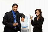 Businessman and businesswoman at water cooler.