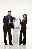 Businessman and businesswoman standing at water cooler.