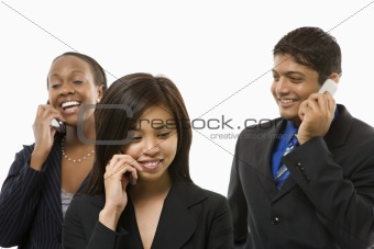 Businesswomen and businessman talking on cell phones.