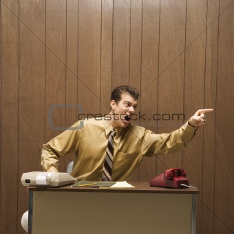 Retro business scene of angry man at desk.