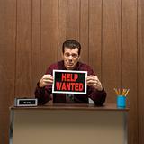 Retro businessman holding help wanted sign.