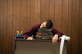 Overworked retro businessman sleeping at desk.