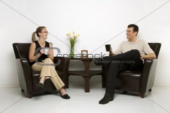 Man and woman sitting drinking coffee.