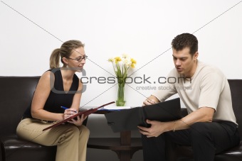 Man and woman sitting looking at portfolios.