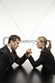 Man and woman arm wrestling on table.