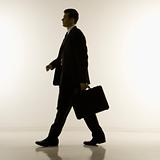 Silhouette of businessman walking with briefcase.