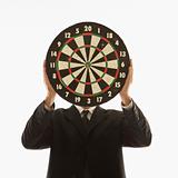 Man holding dartboard in front of face.