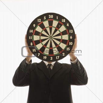 Man holding dartboard in front of face.