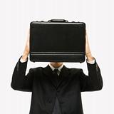 Man holding briefcase in front of face.