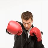 Man in suit wearing boxing gloves.