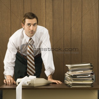 Man with hands on desk.